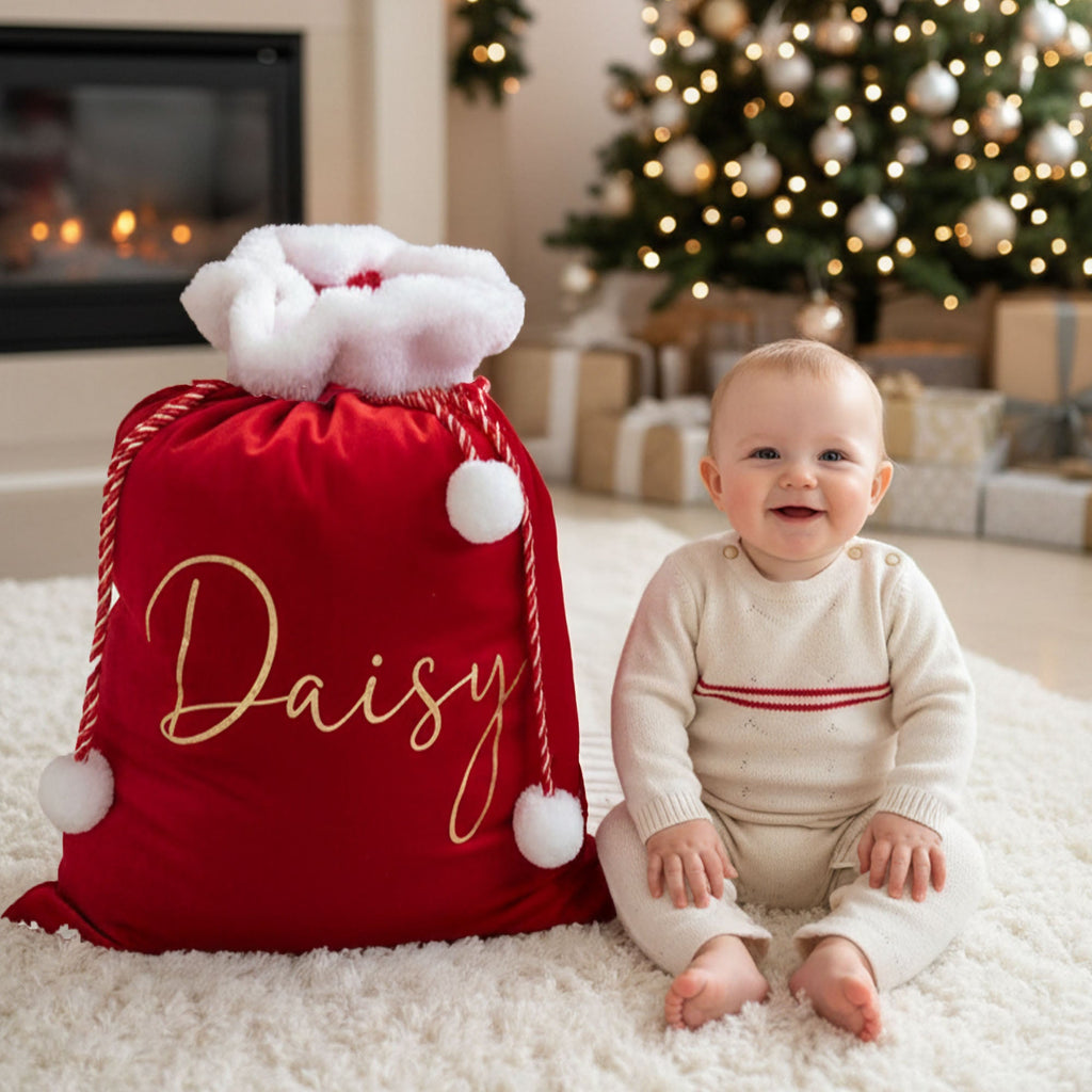 Santa sack with baby in front of tree